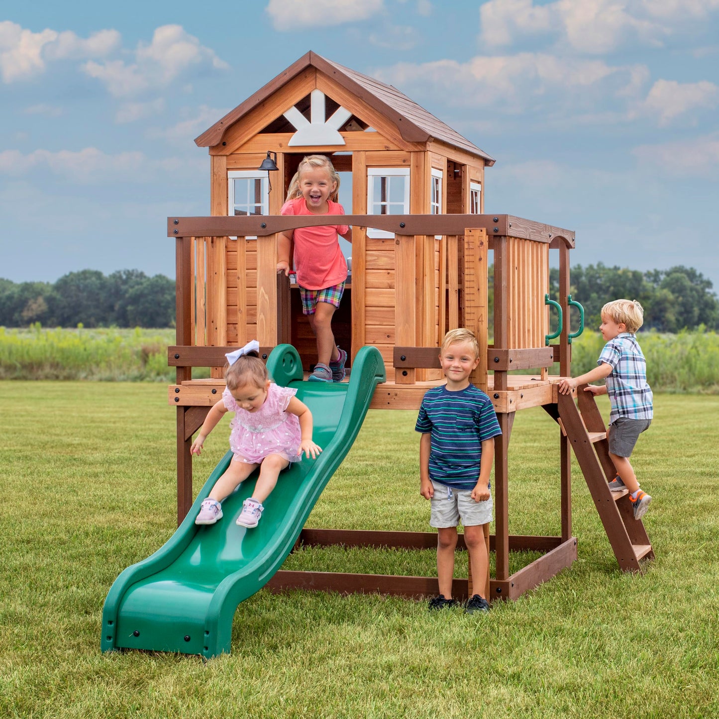 Backyard Discovery Echo Heights Elevated Cedar Wooden Kids Playhouse with Wave Slide, Play Kitchen, Wrap-Around Deck, Flat-Step Ladder, Half Door, Windows, Bell, and Growth Chart for Outdoor Play
